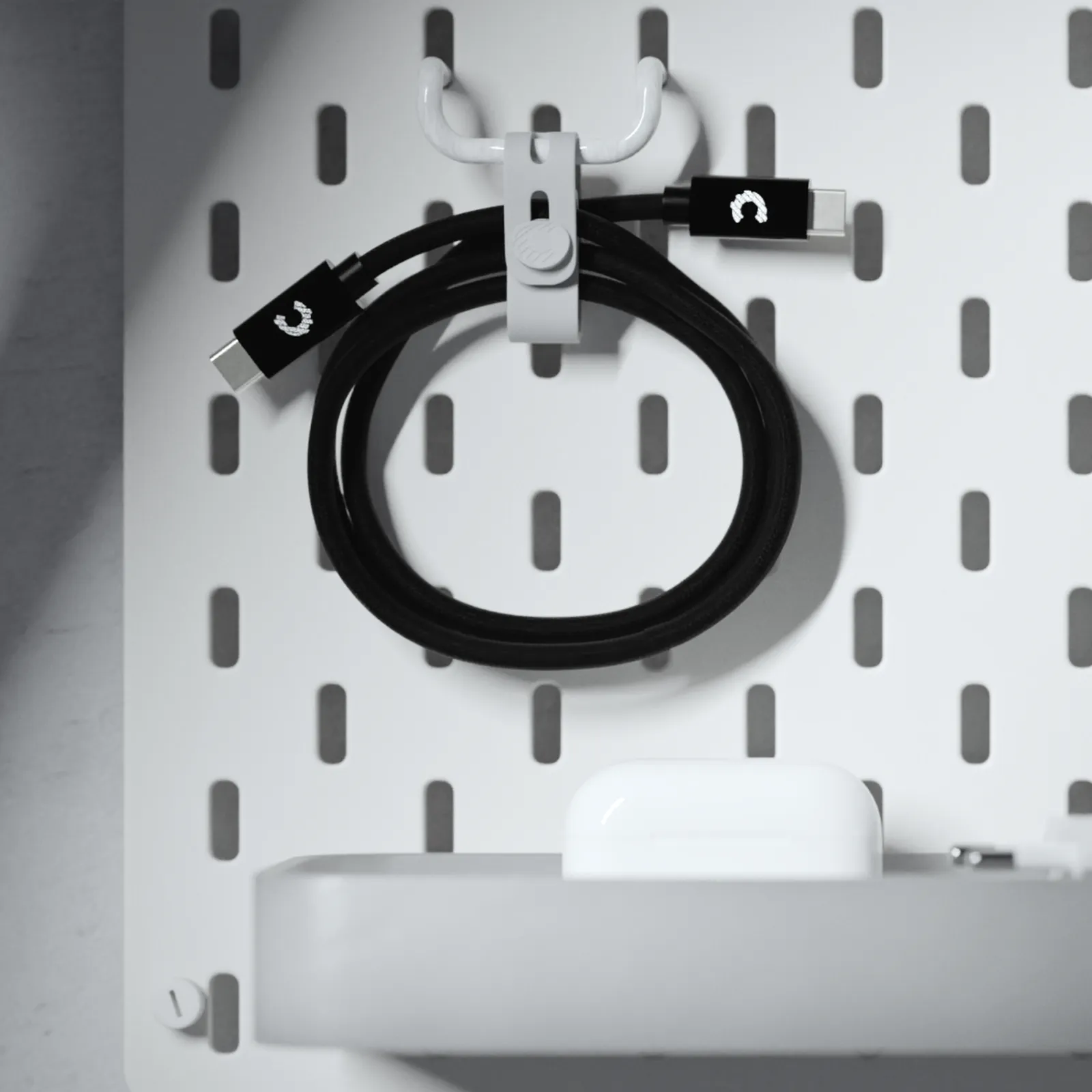 Coiled Creator Cable with a white silicone strap on a pegboard